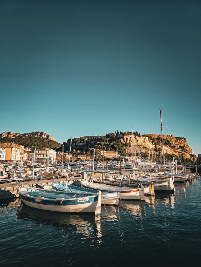 Picturesque harbor scene in Cassis, France, showcasing boats against the backdrop of captivating cliffs.